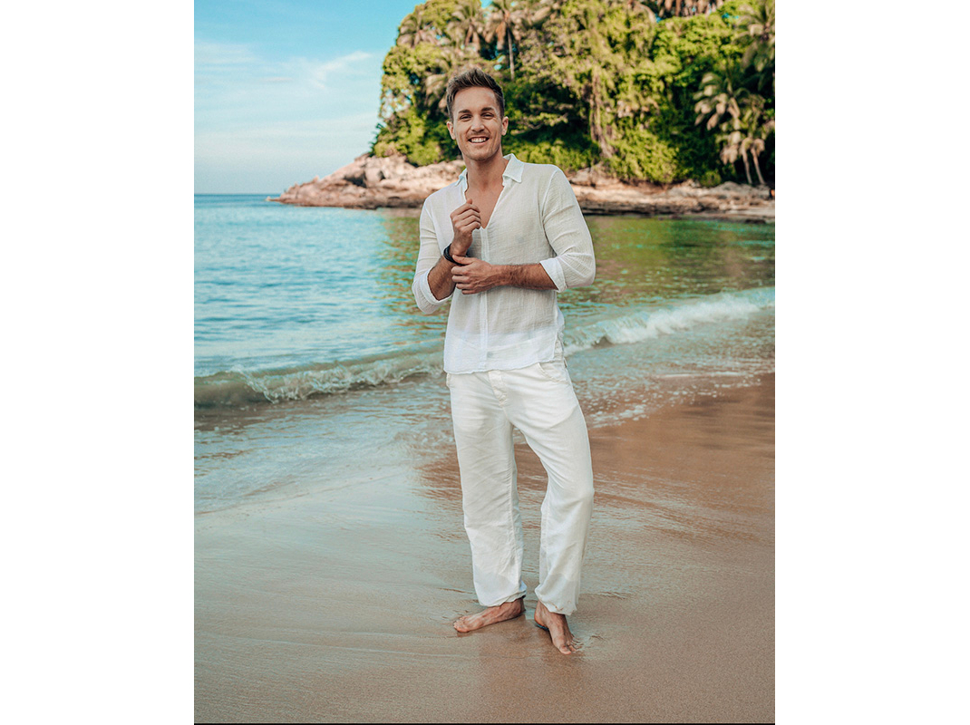 Male Model ganz in weiss am Strand